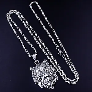 Dettaglio macro del ciondolo a testa di leone in argento con catena box su sfondo nero