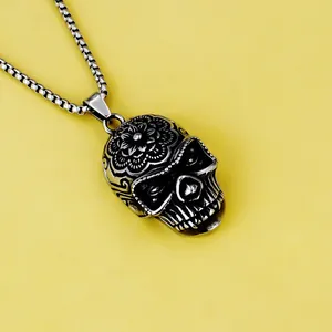 Détail macro d'un pendentif crâne rétro en acier inoxydable avec gravures florales complexes