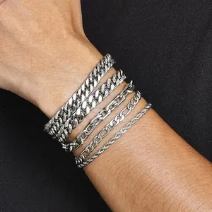Close-up of four stacked silver stainless steel cuban, paperclip, and rope chains on wrist