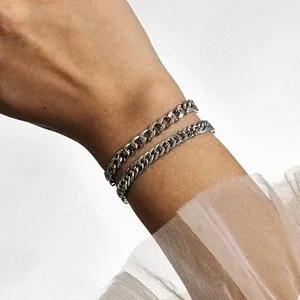 Detail of silver stainless steel Cuban link bracelets in various thicknesses on wrist