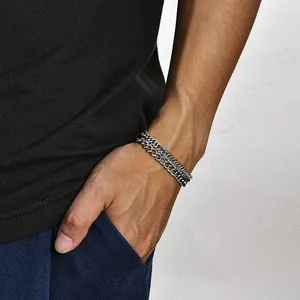 Detailed close-up of a silver-toned double layered Cuban link chain bracelet for men
