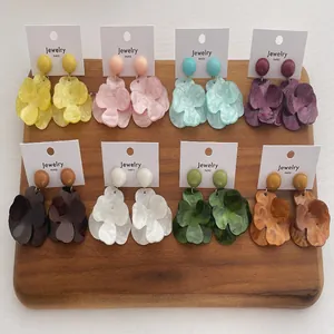 Detail view of colorful acrylic flower earrings in eight retro colors on display cards