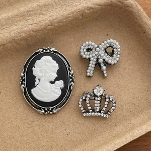 Vintage style brooch set featuring retro cameo, pearl bow, and crown crystal pin