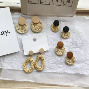 Close-up of handmade geometric woven rattan earrings in round and teardrop shapes