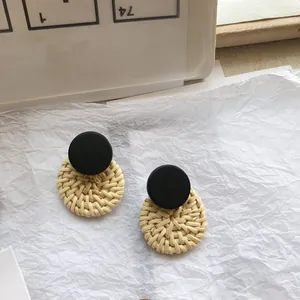 Handmade geometric circular woven earrings in a natural wood and black color block design