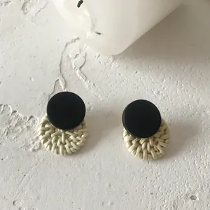 Vintage bohemian earrings with black wood studs and woven beige circular straw pendants