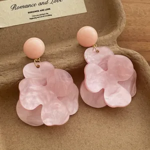 Detail shot of vintage pink floral drop earrings with a marble-textured resin finish