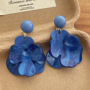 Detail of French vintage blue marble resin flower drop earrings on artistic background