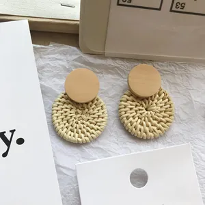 Handmade bohemian style round woven straw earrings with natural wood stud detail