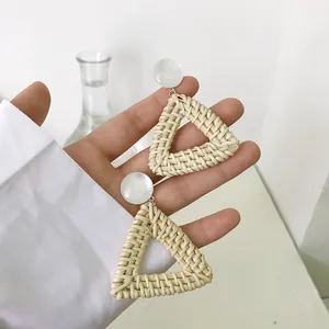 Natural woven rattan triangle drop earrings with white round studs and gold ring accents