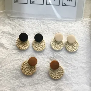 Flat lay of three pairs of vintage round rattan and wooden earrings in natural tones