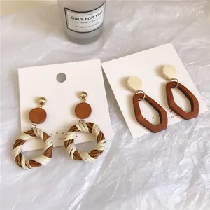 Retro bohemian earrings with wood and wicker woven accents on white display card