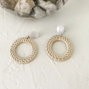 Bohemian round woven rattan earrings with white resin studs for a summer vacation look