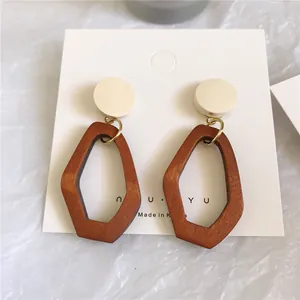 Minimalist geometric earrings with round white studs and red-brown wood pendants