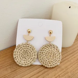 Handmade bohemian rattan earrings with golden studs and beige semi-circular details