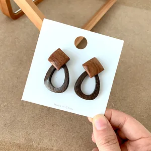 Detail view of geometric wood earrings with contrast texture on a cardholder
