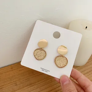 Detail of bohemian gold metal and handmade rattan earrings with S925 silver posts