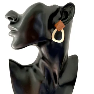 Detail of geometric wood and resin drop earrings on a professional jewelry display