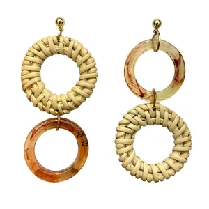 Detailed view of handmade rattan and amber resin drop earrings with marble pattern