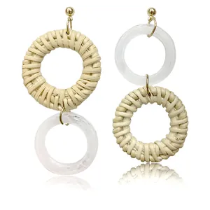 Close-up of asymmetrical woven rattan and white resin geometric drop earrings