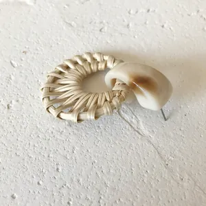 Detail of woven rattan and cream resin earring with vintage bohemian style finish