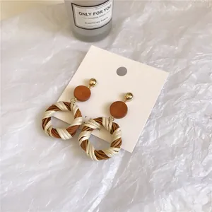 Bohemian style woven hoop earrings with brown and cream textures on display card