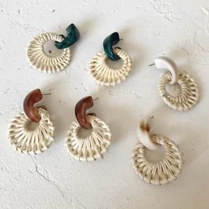 Detail of bohemian resin earrings with natural woven rattan texture and marble finish