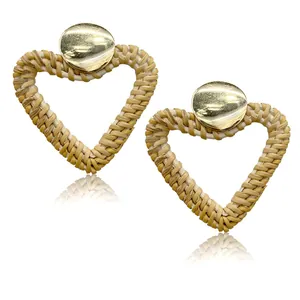 Detailed view of woven heart drop earrings with gold metal studs in bohemian style