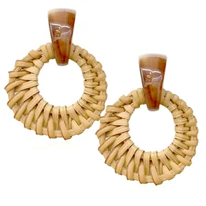 Amber resin drop earrings with large woven rattan hoops on a clean white background