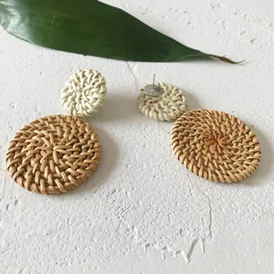 Detail van handgemaakte bohemien dubbele ronde rotan oorbellen op een witte achtergrond