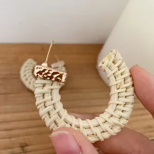 Handmade C-shaped rattan hoop earrings with gold hammered metal accents in boho style