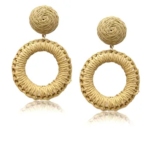 Close-up of bohemian woven rattan round drop earrings with intricate natural texture