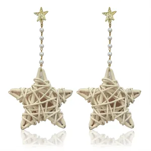 Macro detail of star-shaped rattan earrings with delicate pearls and golden studs