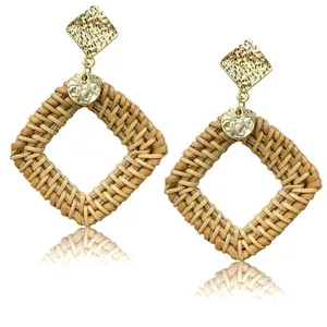 Detail of square woven rattan earrings with hammered gold metal posts in boho style