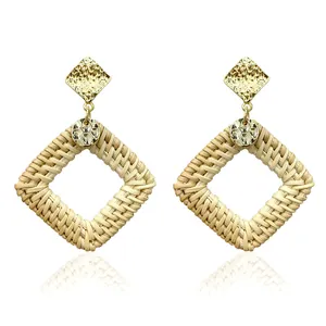 Detailed view of bohemian square rattan drop earrings with hammered gold metal studs