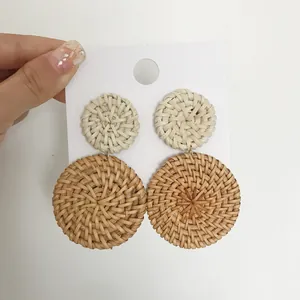 Detail van dubbele cirkel rotan oorbellen met natuurlijke geweven textuur en boho-stijl