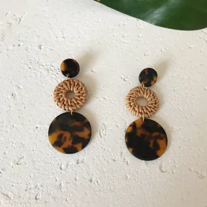 Nahaufnahme böhmischer Ohrringe mit Schildpatt-Resin und handgeflochtenen Rattan-Elementen