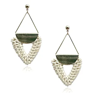 Detailed view of bohemian gold geometric metal and hand-woven rattan pendant earrings