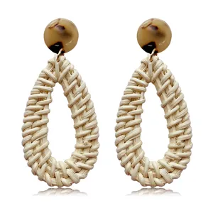 Detail of bohemian rattan teardrop earrings with tortoiseshell resin and woven fiber