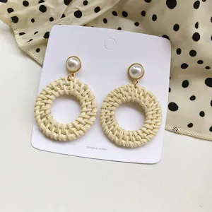 Handmade woven rattan hoop earrings with pearl accents and bohemian geometric style