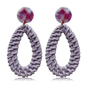 Detailed view of handmade purple woven teardrop earrings with marble acrylic studs