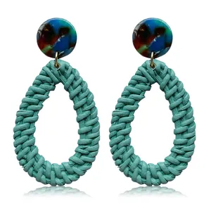 Detail of bohemian water-drop earrings featuring mint green woven fiber and marble resin