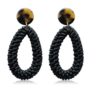 Macro shot of rattan teardrop earrings with tortoiseshell texture and woven detail