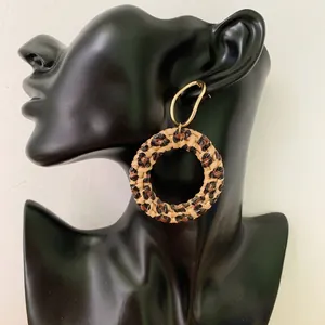 Close-up of leopard print woven hoop earrings displayed on a black mannequin model