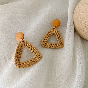 Detail shot of bohemian handmade rattan diamond earrings with circular wood studs