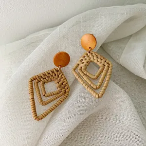 Handmade bohemian rattan earrings with geometric orange wood studs and woven diamond charms