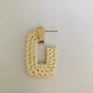 Macro detail of Bohemian half-circle rattan earring with textured gold metal fastener