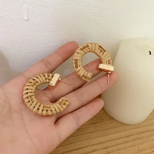 Handmade Bohemian C-shaped woven rattan hoop earrings with gold-toned metal accents