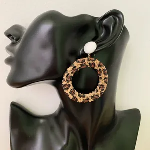 Close-up of leopard print woven hoop earrings displayed on a mannequin head
