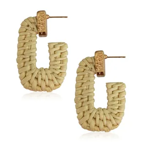 Bohemian rectangular woven rattan earrings with hammered gold metal studs on white background